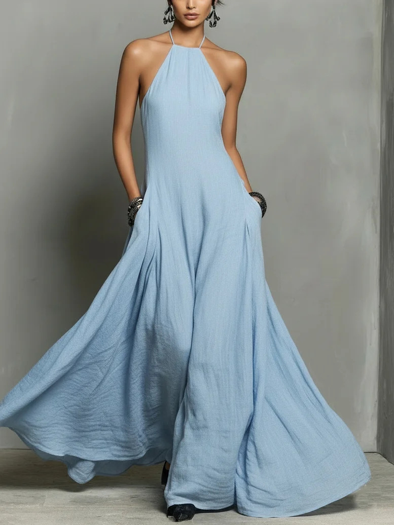 Woman wearing a long light blue dress against a gray background