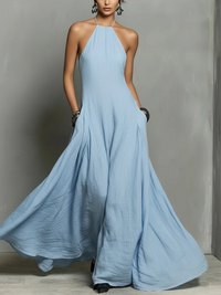 Woman wearing a long light blue dress against a gray background