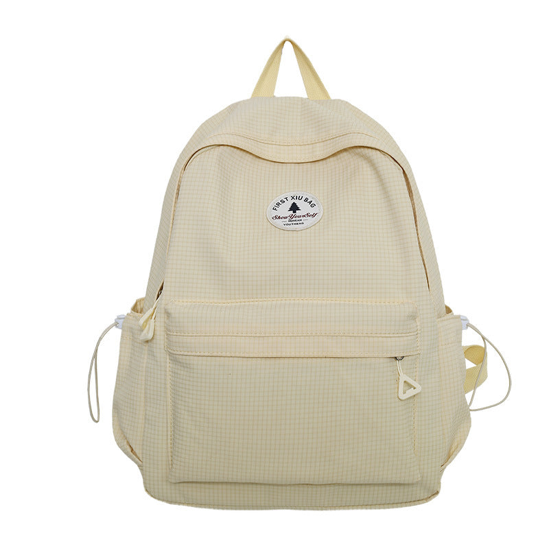 A light beige gingham backpack with a front zippered pocket and a circular 'Tree Mineral' logo patch on the upper front, shown against a plain white background.